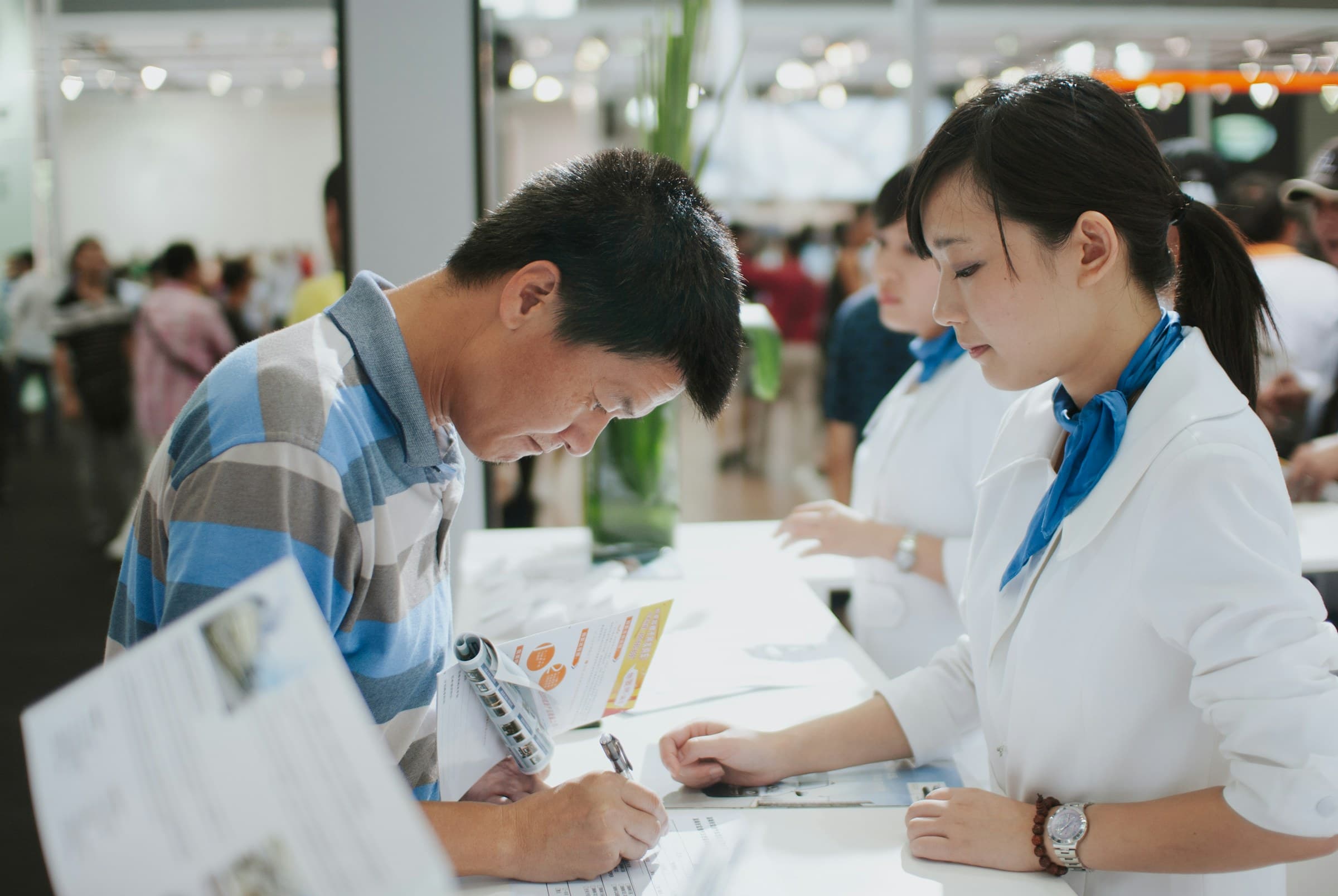 Delegates collecting name badges at a conference registration desk